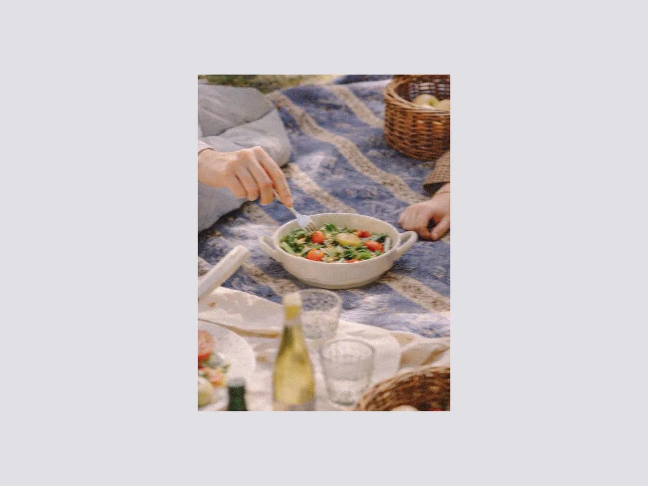 Shared salad served in a ceramic bowl with picnic cutlery and glasses on a blanket, styled with easter table decorations and designer tableware for relaxed outdoor dining and gift suggestions for easter.
