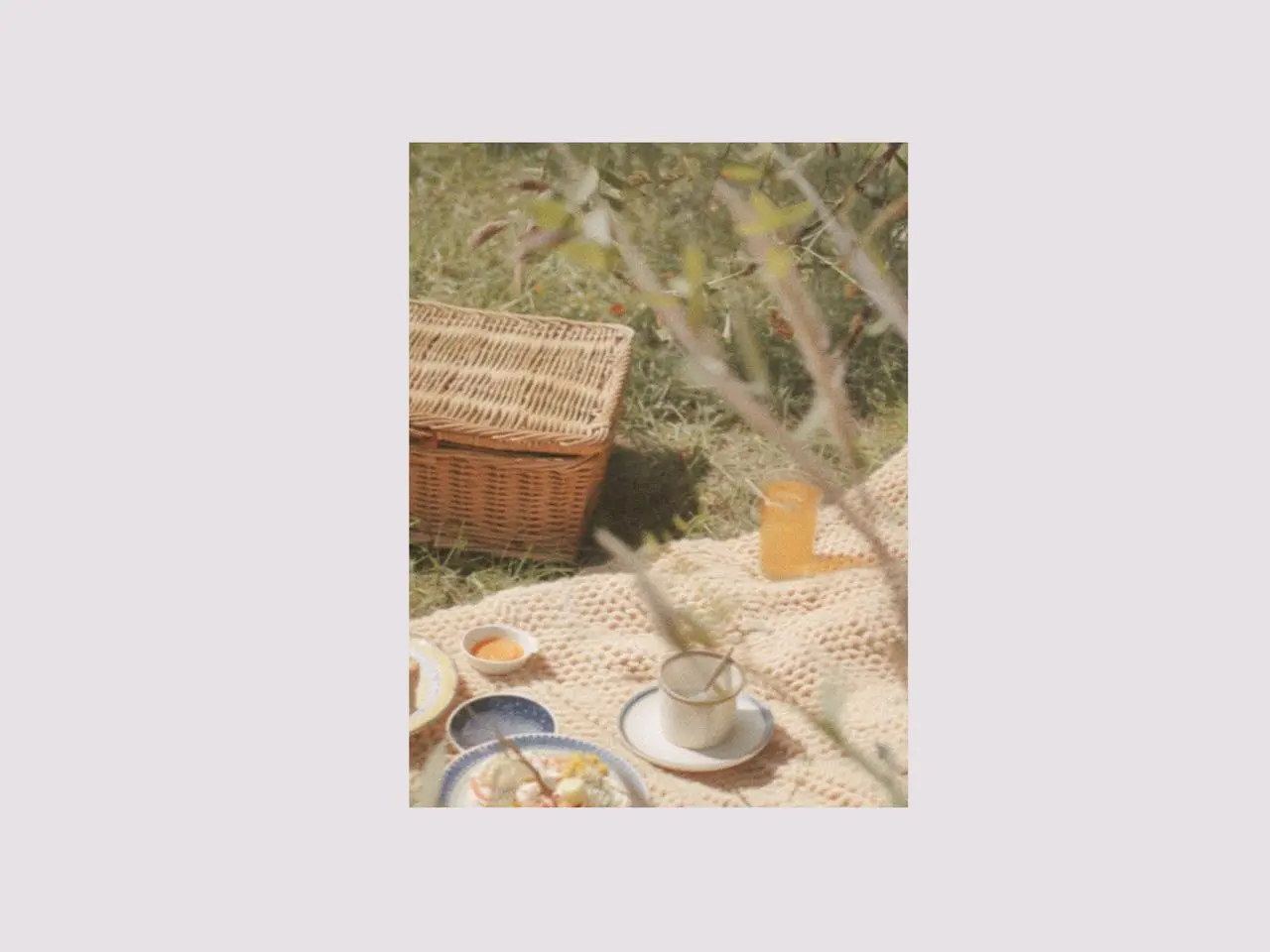 Relaxed picnic afternoon tea scene with picnic dinnerware set, ceramic painting plates, ice cream cups, and picnic cutlery arranged on a blanket, creating a calm outdoor setting for a family picnic.