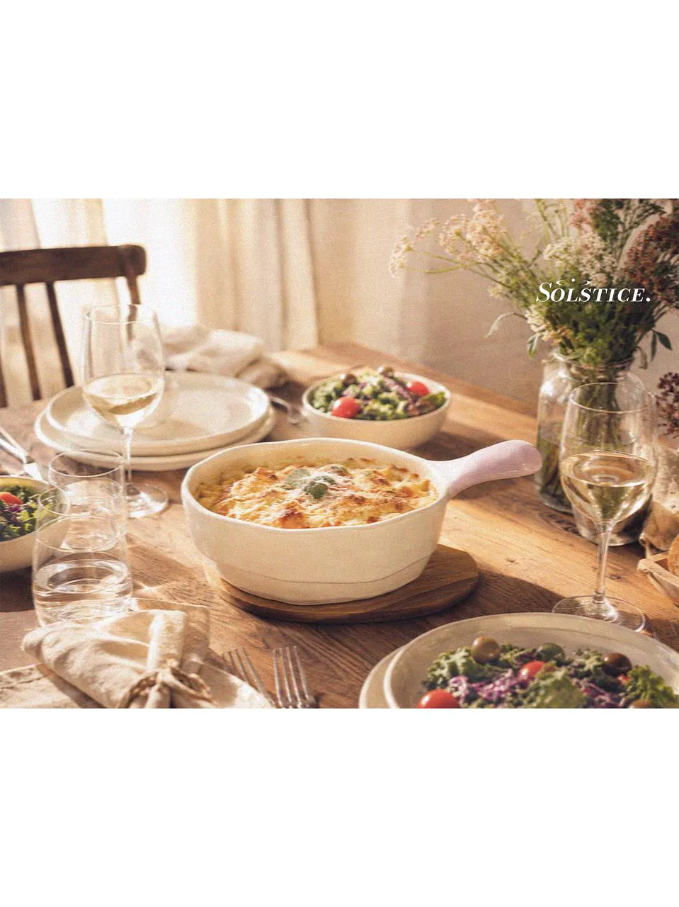 Wooden dining table with picnic bowls, ceramic plates set, salad plates, and a large salad bowl, styled with picnic dinnerware and designer tableware for a relaxed shared evening meal.
