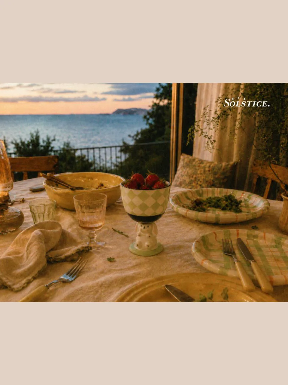 Evening dining table with picnic dinnerware, ceramic plates set, salad plates, ice cream cups, and a large salad bowl, styled with designer tableware for a calm and natural shared meal by the sea.