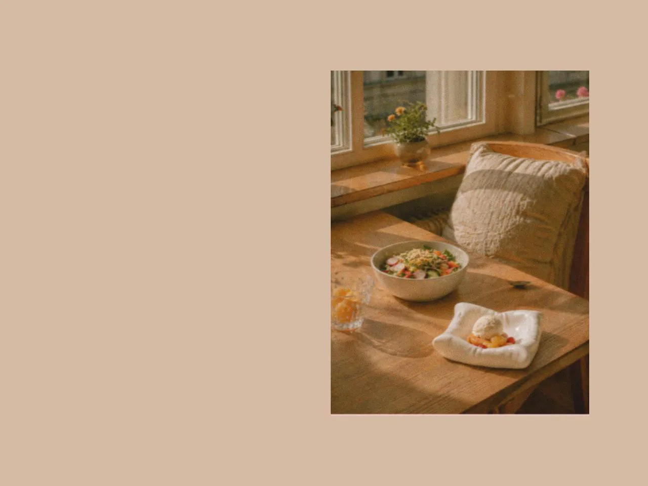 Wooden table styled with a square plate, large salad bowl, and picnic dinnerware, paired with simple picnic accessories and designer tableware for a light family picnic and fruit salad sweet meal.